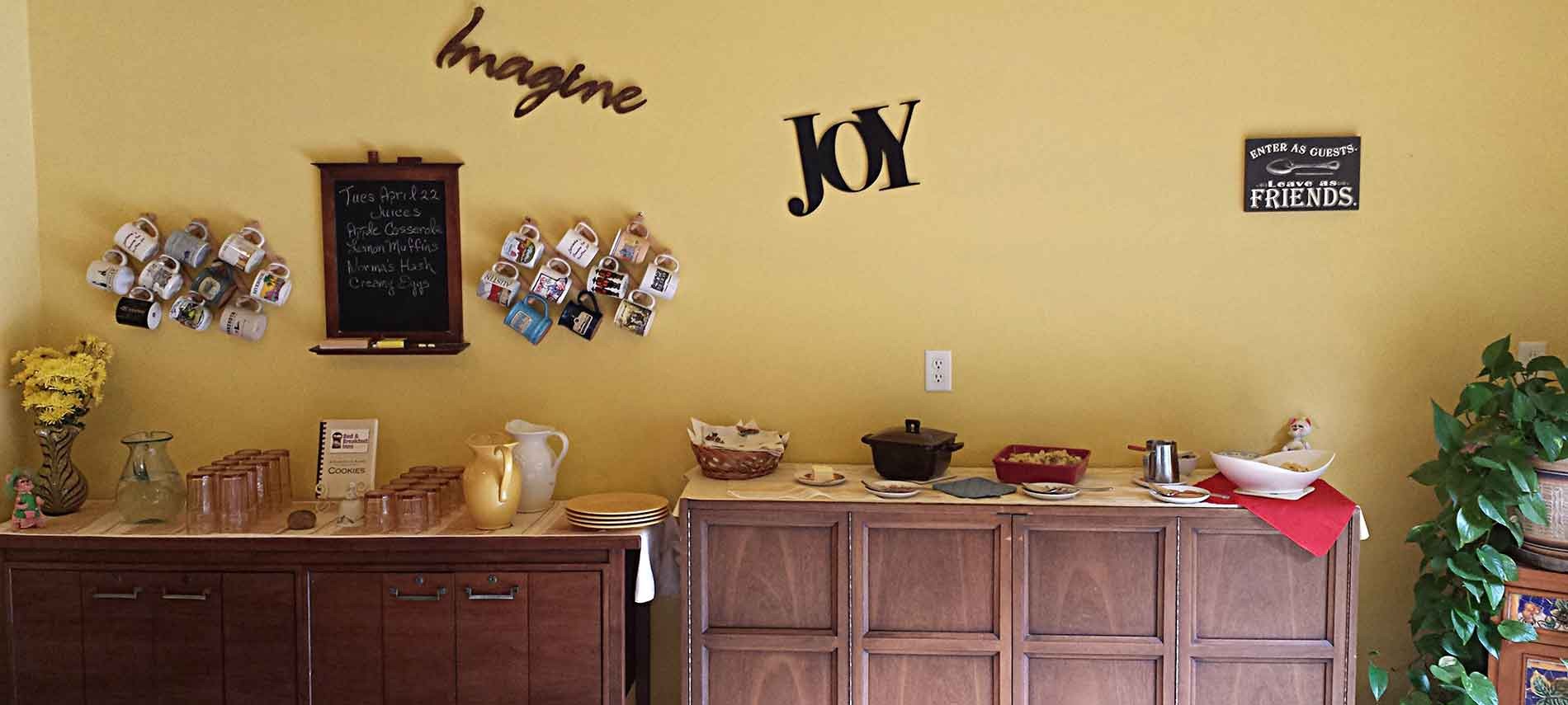 Buffet meal set atop two buffets and words on the wall above the buffet and flowers in the left corner